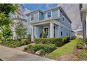Beautiful two-story home with lush landscaping and a brick pathway leading to a cozy front porch at 14374 Lanikai Beach Dr, Orlando, FL 32827
