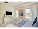 Bright main bedroom featuring a sleek TV console, neutral tones, and ample natural light from large windows at 1624 Tropical Palms Cir, Kissimmee, FL 34747