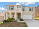 Two-story home with a two-car garage, porch, and green shutters and door under a blue and cloudy sky at 1830 Juneberry St, Clermont, FL 34715