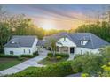 Stunning single-story home featuring lush landscaping, porte cochere, and a paver driveway at sunset at 1906 Oakbrook Dr, Longwood, FL 32779