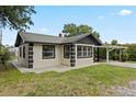 Charming single-story home with green roof, featuring a well-maintained lawn and a carport at 207 Rose St, Auburndale, FL 33823