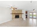 Open-concept living room with tile floors, stone fireplace, ceiling fan, and access to the pool area at 2314 Meadowbrook St, Kissimmee, FL 34744