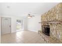 Living room featuring a stone fireplace, neutral tile flooring, and ample natural light at 2314 Meadowbrook St, Kissimmee, FL 34744
