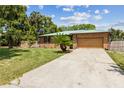 Well-maintained brick home with a spacious driveway, attached garage and a lush front yard at 255 Katrina St, De Leon Springs, FL 32130