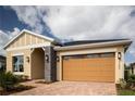 Charming single-Gathering home with neutral paint, a stone accent wall and a two-car garage at 3285 Songbird Cir, Harmony, FL 34773