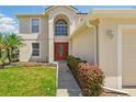 Inviting front entrance featuring a bright red door and manicured shrubs at 343 Grand Royal Cir, Winter Garden, FL 34787