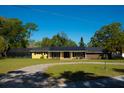 Charming single story home with mature landscaping, a circular driveway, and a screened in back patio at 36019 Clear Lake Dr, Eustis, FL 32736