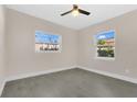 Bright bedroom featuring tile flooring, a ceiling fan, and windows overlooking the landscape at 3713 Dover St, Orlando, FL 32806