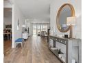 Bright foyer featuring wood-look flooring, modern console table with decor and an attractive round mirror at 4779 Cragmere Loop, Clermont, FL 34711