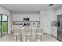 Bright eat-in kitchen with white cabinets, stainless steel appliances, and bar seating at 4928 Bluebell Ct, Lake Hamilton, FL 33851