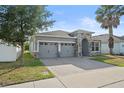 Beautiful single-story home showcasing a stone-accented entry, grey stucco, and a paved driveway at 5108 Creekside Park Ave, Orlando, FL 32811