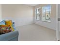 Bright room with natural light, a blue sofa, wainscoting, and carpet flooring at 5108 Creekside Park Ave, Orlando, FL 32811