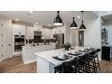Modern kitchen with stainless steel appliances, sleek white cabinetry, and island seating at 536 Moon Shell Cir, New Smyrna Beach, FL 32168