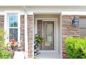 Elegant entryway featuring a decorative glass door, stone accents, and blooming plants at 5510 Siracusa Ln, Sanford, FL 32771