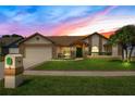 Charming single-story home with lush lawn, brick accents, and a two-car garage, creating inviting curb appeal at 5836 Goldenwood Dr, Orlando, FL 32817