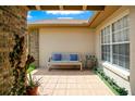 Cozy front patio featuring neutral tile, bench seating, and potted plants at 5836 Goldenwood Dr, Orlando, FL 32817