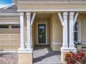 Inviting front porch with decorative columns and a brick-paved entryway, perfect for enjoying the outdoors at 7748 Four Seasons Blvd, Kissimmee, FL 34747