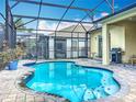 Inviting screened-in pool area complete with brick pavers, barbecue, and a relaxing outdoor space at 7748 Four Seasons Blvd, Kissimmee, FL 34747