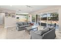 Open living room with neutral colors, access to outdoor pool, and seamless flow to kitchen featuring an eat-in breakfast bar at 7867 Horse Ferry Rd, Orlando, FL 32835