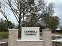 Campbell Crossing community sign framed by decorative stone pillars and mature trees under a cloudy sky at 974 Commons Way, Port Orange, FL 32129