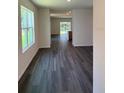 Spacious living room featuring wood-look flooring, lots of natural light, and an open concept at 976 Commons Way, Port Orange, FL 32129