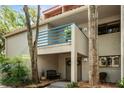 Inviting condo entrance featuring a blue railing balcony, dual front doors adorned with wreaths, and a cozy seating area at 1000 Winderley Pl # 140, Maitland, FL 32751