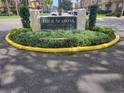 Four Seasons Condominiums street sign surrounded by manicured landscaping and a yellow curb at 200 Saint Andrews Blvd # 2306, Winter Park, FL 32792
