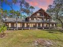 Rustic two-story home featuring exposed beams, a large porch, and a spacious lawn at 3939 Lake Erie Rd, Groveland, FL 34736