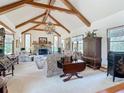 Elegant living room featuring vaulted ceilings, exposed beams, stone fireplace, and stylish furnishings at 3939 Lake Erie Rd, Groveland, FL 34736
