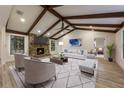 Cozy living room features vaulted ceilings with beams, stone fireplace, and neutral furnishings at 643 Princewood Dr, Deland, FL 32724