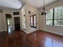 Bright, airy living room with dark wood floors, large windows, and elegant chandelier at 708 Palenci Ct, Winter Springs, FL 32708