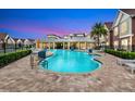 Beautiful community pool with clear water, lounge chairs, and well-maintained landscaping at twilight at 7514 Sunville Ave, Kissimmee, FL 34747