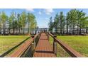 Wooden boardwalk stretches to a covered dock by the lake, inviting leisurely strolls and waterfront enjoyment at 7624 Pointe Venezia Dr, Orlando, FL 32836