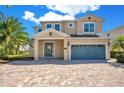 Charming two-story home features a two-car garage and a beautifully paved brick driveway at 7644 Fairfax Dr, Kissimmee, FL 34747