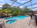 Enjoy a screened-in pool with a spa and lush tropical landscaping at 826 Jade Forest Ave, Orlando, FL 32828