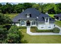 Elegant home with manicured lawn, stone pathway, and a dark roof and lush landscaping at 878 Cardinal Pointe Cv, Sanford, FL 32771