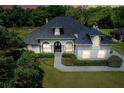A beautiful gray house with a well-manicured lawn and lovely front garden creates a welcoming curb appeal at 878 Cardinal Pointe Cv, Sanford, FL 32771
