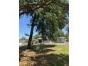 View of the home's backyard with mature trees and a glimpse of the covered patio at 9400 Se 119Th St, Belleview, FL 34420