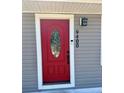 Close-up of the red front door with decorative glass and house number at 9400 Se 119Th St, Belleview, FL 34420