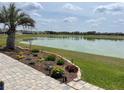 Beautiful backyard with a paver patio, lush landscaping, and serene lake views at 9872 Sw 75Th Street Rd, Ocala, FL 34481