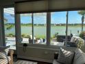 Cozy sunroom with panoramic views of the lake and access to the outdoor patio at 9872 Sw 75Th Street Rd, Ocala, FL 34481
