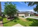 Side view of a well-maintained home with a lush green lawn and mature tree at 1438 Portmoor Way, Winter Garden, FL 34787