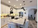 Modern kitchen with white cabinets, a breakfast bar, and stainless steel appliances at 308 Rustic Loop, Sanford, FL 32771