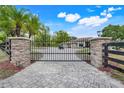Elegant gated entrance with brick pillars and secure black metal gate at 32510 Wolf Branch Ln, Sorrento, FL 32776