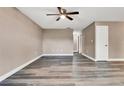 Living room with fresh paint, baseboards, ceiling fan, grey wood-look floors and natural light at 516 Polaris Loop # 110, Casselberry, FL 32707
