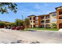 Apartment complex exterior showcases ample parking and well-manicured green spaces for residents at 5512 Metrowest Blvd # 203, Orlando, FL 32811