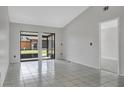 Bright and airy living room featuring white tile floors and access to an enclosed back patio at 66 Silver Falls Cir, Kissimmee, FL 34743