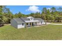 Charming, modern farmhouse with board and batten siding, metal roof, and a well maintained lawn at 6725 Sw 131St Cir, Ocala, FL 34481