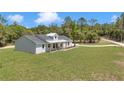 Exterior view of a charming home with a covered porch, wooden pillars, and an extended driveway at 6725 Sw 131St Cir, Ocala, FL 34481