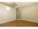 Cozy bedroom featuring wood-look flooring, neutral walls, and arched doorway at 11547 Grazeley Ct, Orlando, FL 32837